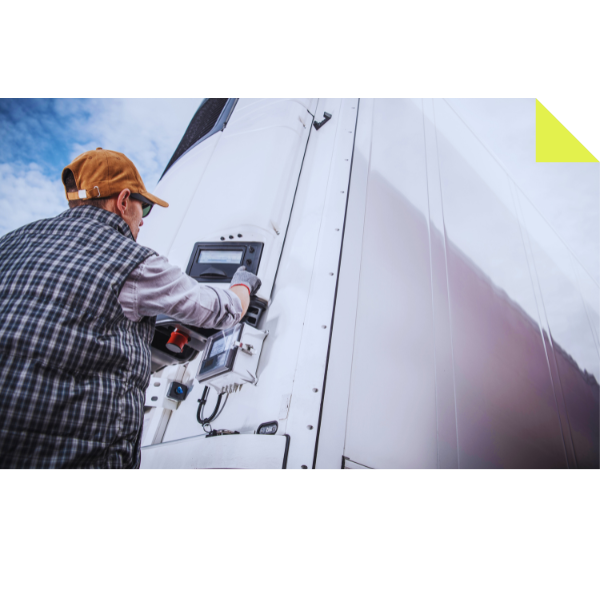 A person in a plaid vest and orange cap operates a control panel on the side of a large white truck, showcasing the efficiency of RDT Enterprises. The sky is partly cloudy in the background.